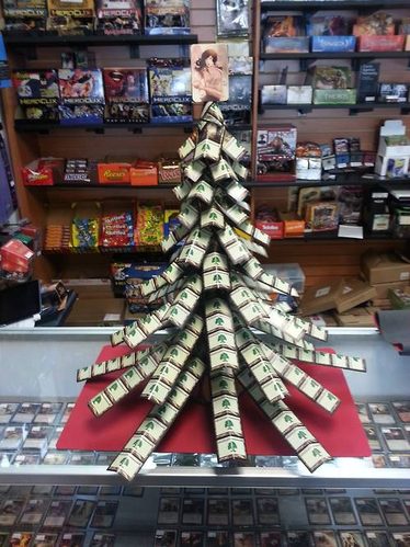 Albero di Natale fatto con le bustine dei booster, in un negozio di giochi
