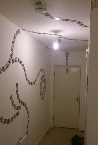 Fila di carte Magic disposta lungo pareti e soffitto di un corridoio